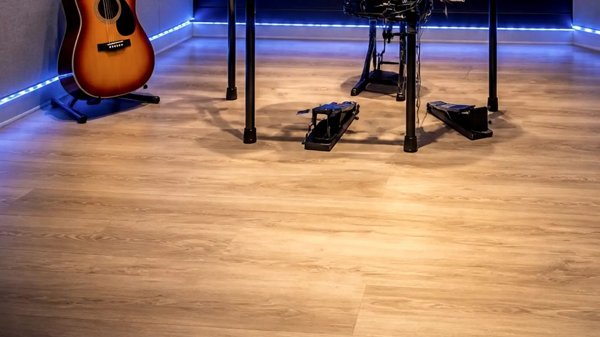 The live room at DJ Studio 37: acoustic treatment, drum kit and guitar under blue light