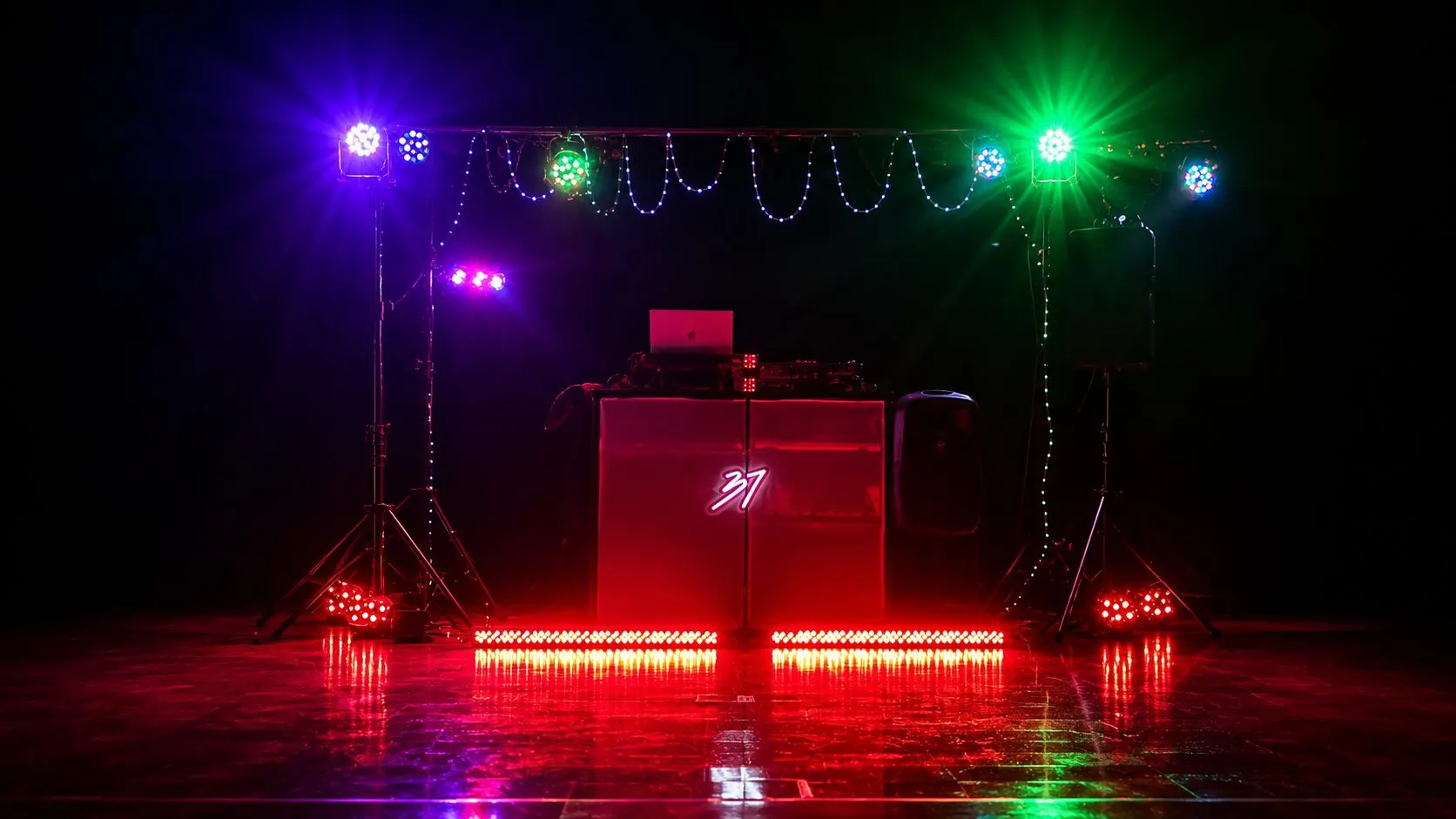 The full DJ Studio 37 rig lit in blue, green and red on an empty reflective floor