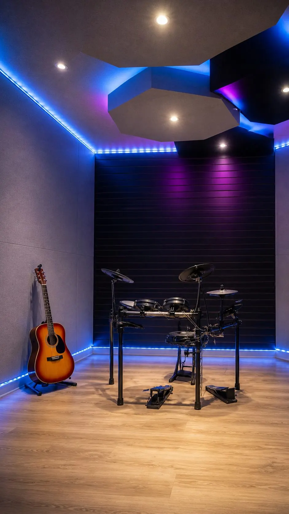 The live room at DJ Studio 37, an electronic drum kit and an acoustic guitar under blue and magenta lighting